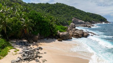 Berrak turkuaz suyu ve kayalık çıkıntıları olan tropik bir sahil. Seyşeller, Mahe. Anse Boileau.
