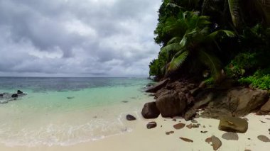 Yumuşak kum, dağınık kayalar ve kristal berrak turkuaz suyu olan huzurlu bir sahil. Anse Bougainville. Seyşeller, Mahe.