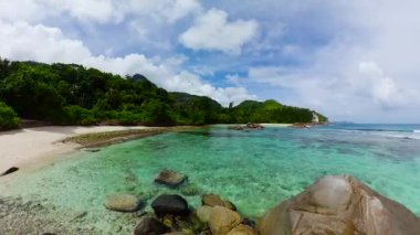 Berrak sularla çevrili sığ bir turkuaz göl, yemyeşil ve kumlu bir plajla çevrili. Port Glaud Gölü. Seyşeller, Mahe.