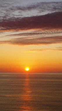 Aerial view of Sunset above the sea surface with waves, top view. Reflected sun on a water surface