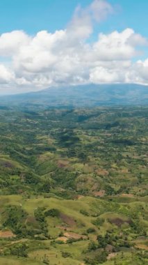 Mavi gökyüzünün arka planındaki tarım arazisi manzarası ve dağlık bir alandaki bulutlar. Zenciler, Filipinler