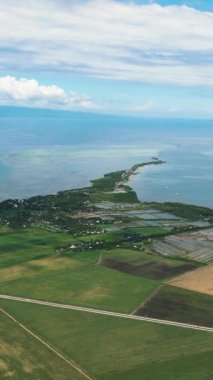 Aerial view of island coastline with farmland and town. Negros, Philippines.