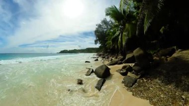 Yumuşak altın kumu, tropikal yeşilliği ve ufka doğru uzanan nazik turkuaz dalgaları olan sakin bir sahil. Seyşeller, Mahe.