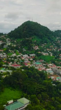 Bereketli yeşilliklerin arasına yerleşmiş dağınık evleri olan tepe kenarı topluluğu. Victoria şehri. Seyşeller, Mahe.