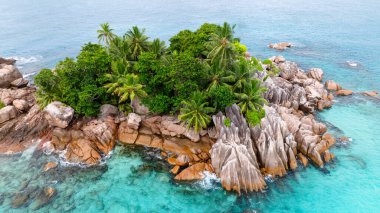 Canlı yeşil bitki örtüsü ve kristal berrak sularla çevrili çarpıcı granit kaya oluşumlarının yer aldığı tropik bir ada. St Pierre Adası. Seyşeller.