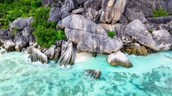 Tropikal kıyı şeridini turkuaz sular ve küçük plajlarla kaplayan granit kayalar. La Digue, Seyşeller.