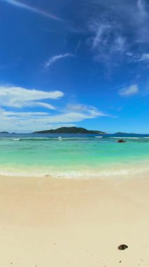 Turkuaz suyu ve yemyeşil tropikal ağaçları olan yumuşak beyaz kumsal. Seyşeller, La Digue.