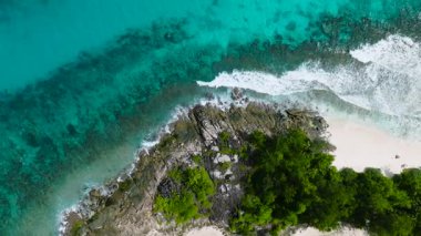 Beyaz kumu, yemyeşil tropikal bitki örtüsü ve gök mavisi suları olan bir ada sahili. Seyşeller, Mahe.