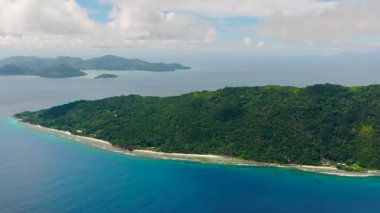 Bereketli tropikal ormanları olan ve kayalık kıyılara sahip berrak mavi sularla çevrili bir ada. Seyşeller, La Digue.