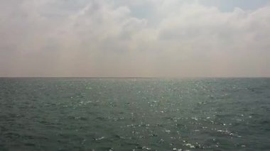 Dalgalı mavi okyanus ve bulutlu mavi gökyüzü. Mavi su ve gökyüzü manzarası.