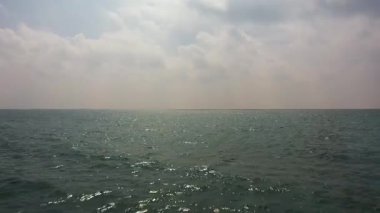 Dalgalı mavi okyanus ve bulutlu mavi gökyüzü. Mavi su ve gökyüzü manzarası.