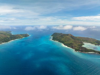 Turkuaz körfezi iki yemyeşil tepenin arasına kurulmuş, uçsuz bucaksız okyanusa açılıyor. Praslin, Seyşeller.