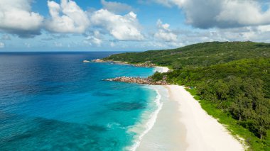 Turkuaz suları, beyaz kumu ve yemyeşil arkaplanı olan çarpıcı bir tropikal plaj. La Digue, Seyşeller. Grand Anse ve Petite Anse plajları.