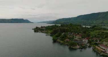 Toba Gölü ve Samosir Adası 'nın insansız hava aracı. Tuk Tuk geleneksel köy ve turizm merkezi. Sumatra, Endonezya. Tropikal manzara.