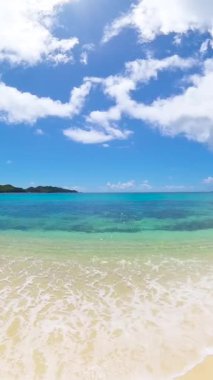 Altın kumu, yemyeşil bitkileri ve parlak gökyüzünün altında turkuaz suyu olan manzaralı tropik bir sahil. Seyşeller, Praslin.