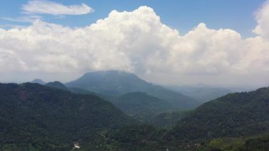 Mountains covered rainforest, trees and blue sky with clouds. Sri Lanka.