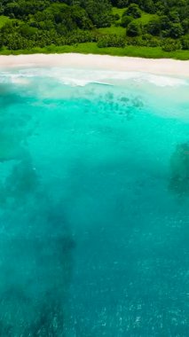 Sakin turkuaz suları olan beyaz kumlu bir sahil manzarası. Anse Cocos plajı. La Digue, Seyşeller.