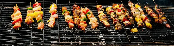 stock image Close-up of colorful kebabs on the grill, featuring marinated meat, bell peppers, and onions, with steam rising.
