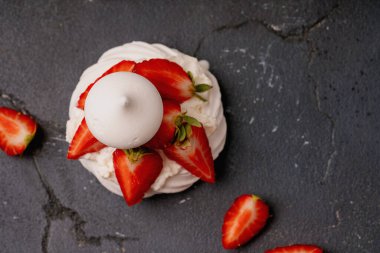 Krem şantili ve koyu dokulu taze çilek dilimli kremalı kremalı bir tatlı. Kıtır ayrıntılar ve canlı renkler bileşimi güçlendirir.