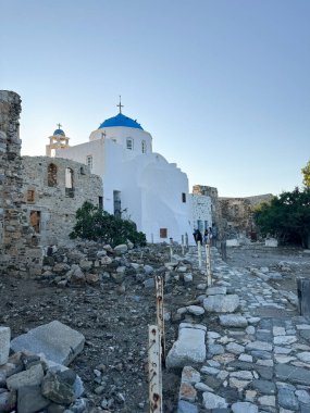 Astypalaia 'da mavi bir kubbesi olan, Ege Denizi' ndeki bir Yunan adası. Taş kalıntıları, kıyı manzarası ve açık mavi gökyüzü geleneksel Akdeniz mimarisini ön plana çıkarıyor.