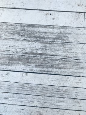 Yıpranmış ahşap tahtaların, görünür tahılların ve eski dokuların üst görüntüsü. Kırsal ve klasik estetik. Yumuşak doğal ışık, solgun ve sıkıntılı yüzeyi vurgular. Arkaplan veya tasarım projeleri için mükemmel.