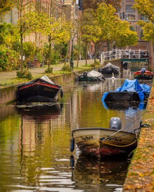 Leiden, Hollanda - 30 Ekim 2022: Doelengracht boyunca Leiden 'da ağaçlar, binalar ve teknelerle dolu resim gibi bir kanal.