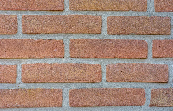 stock image close up view of bright red brick wall with bright gray grout