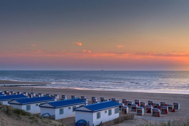 Katwijk aan Zee, Hollanda - 11 Haziran 2015: Katwijk 'te günbatımında kumsaldaki ev ve kulübelerin görüntüsü