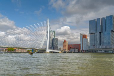 Rotterdam, The Netherlands- May 14, 2016: The Kop van Zuid in Rotterdam on a summer day. A boat from Port of Rotterdam sails over the Maas clipart