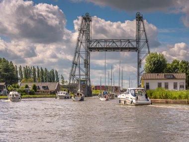 Alphen aan den Rijn, Hollanda - 26 Temmuz 2020: Alphen aan den Rijn 'deki çelik kaldırma köprüsü güzel güneşli bir yaz gününde keyif yatları ve yelkenli gemiler geçiyor