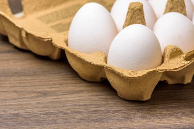 Kartondan yumurta kartonunda, ceviz ağacından yapılmış bir masada.