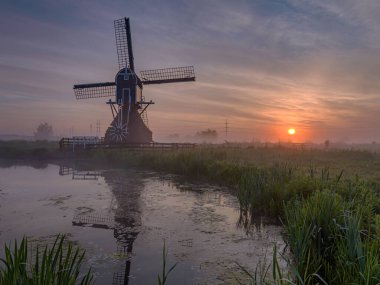 Leiderdorp, Hollanda - 8 Mayıs 2020: değirmende gün doğumunun panoramik görüntüsü. Güney Hollanda 'da Leiderdorp' taki Munnikenpolder 'de tipik bir Hollanda manzara resmi