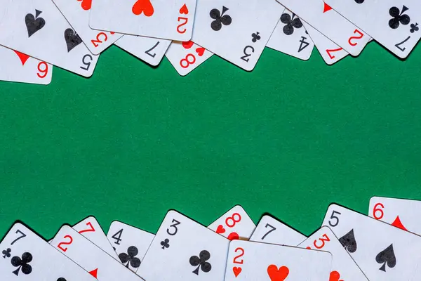Playing cards on green felt casino table. Background with copy space