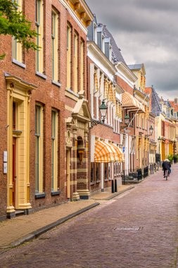 Leeuwarden, Hollanda - 12 Haziran 2021: The Grote Kerkstraat Leeuwarden 'ın merkezinde bir bisikletçiyle birlikte