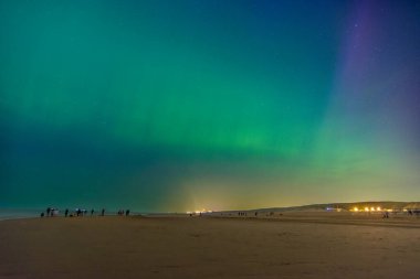 Northern lights at the beach of Katwijk aan zee, Netherlands, green Aurora borealis clipart