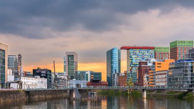 Düsseldorf, Almanya - 7 Mayıs 2024: Medienhafen 'de gün batımı. Düsseldorf 'taki liman bölgesinde eski ve modern binalar var..