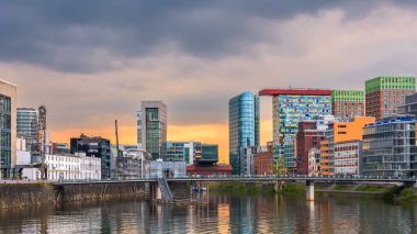 Düsseldorf, Almanya - 7 Mayıs 2024: Medienhafen 'de gün batımı. Düsseldorf 'taki liman bölgesinde eski ve modern binalar var..