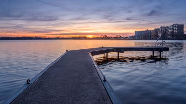 İskeleli bir gölün üzerinde güzel bir gün batımı