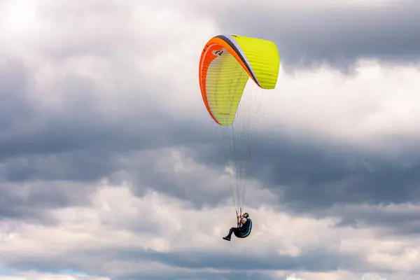  Gökyüzünde bulutların arka planında uçan paraglider
