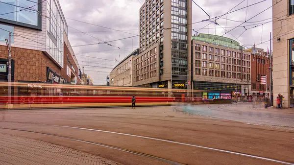Hollanda, Lahey 'in hareketli şehir merkezinde hareket halindeki bir tramvayı çeken dinamik uzun pozlu bir fotoğraf.
