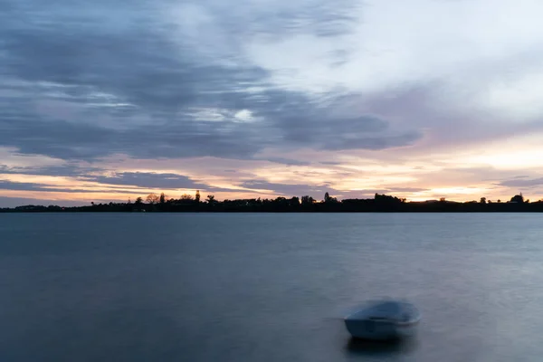 牛郎港日出深空色彩斑斓的轮廓 地平线上的陆地和小艇印的前景 — 图库照片