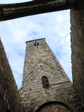 Kadim taş kule gökyüzüne doğru yükseliyor beyaz bulutlu mavi gökyüzüne