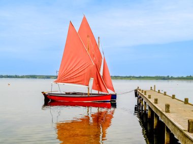 İngiltere 'deki su deposuna demirlemiş kırmızı yelkenli iki yelkenli..