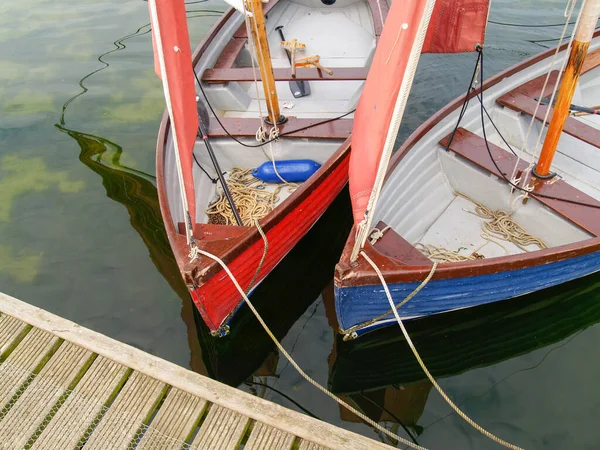 イギリスの貯水池の上に桟橋に係留された赤い帆を持つ2つのセーリングの神々 — ストック写真