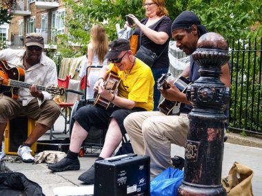 Londra İngiltere - Temmuz 2009; Londra 'daki Columbia Road Market' te gölge altında yürüyen insanlar.
