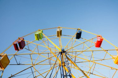 Mavi gökyüzüne karşı eski moda atlıkarıncaların sarı çelik yapısı.