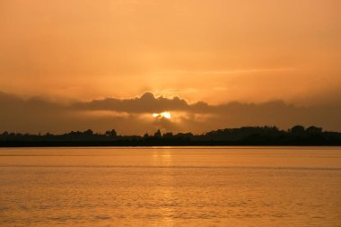 deep moody sunrise over bay in strong golden hues at Tauranga New Zealand.
