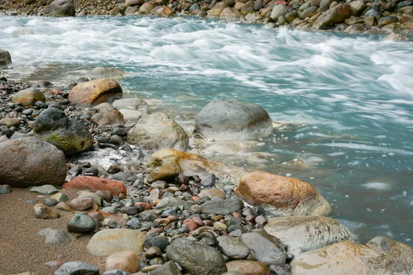 Turquoise Whangaehu River flowing over and through rocky terrain in North Island New Zealand.