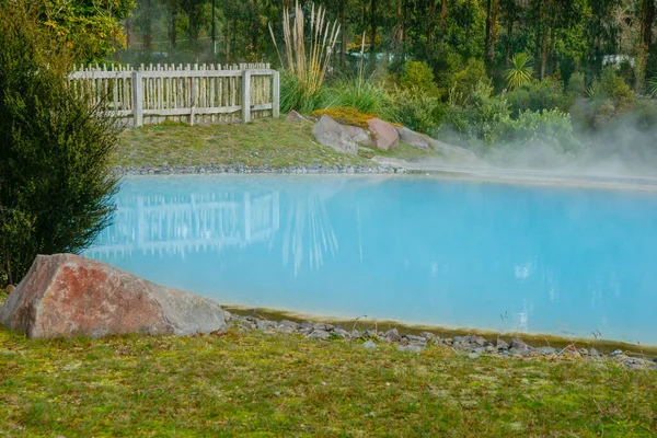 Thermal pool in public area steaming and hot turquoise water.