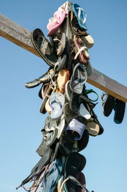 Castle Point New Zealand - October 5 2010: Collection lost footwear attached to cross on beach, Home of Lost Soles vertical composition.closeup.